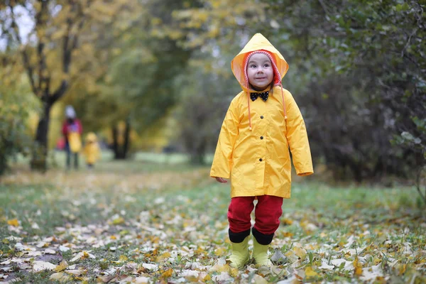 Ein Kind im Regenmantel für einen Spaziergang im Freien — Stockfoto