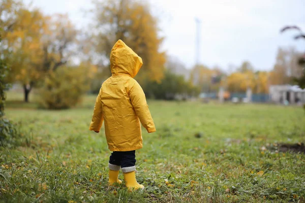 Un niño en un impermeable para un paseo al aire libre —  Fotos de Stock