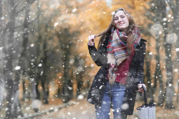 Una ragazza nel parco nella prima nevicata — Foto Stock