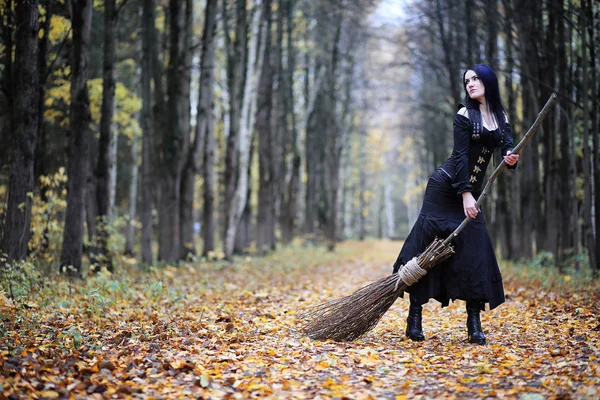 Una mujer con un traje de bruja en un bosque — Foto de Stock