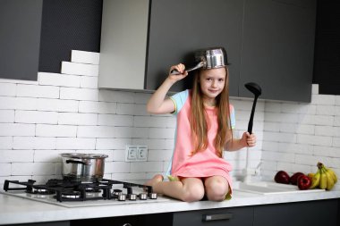 Küçük kız mutfakta. 