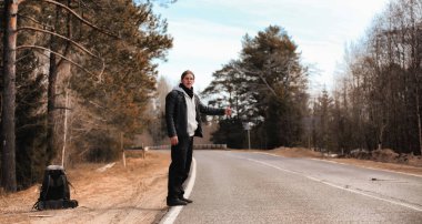 Genç bir adam ülke çapında otostop. Adam çalışıyor