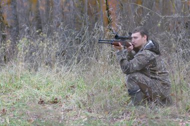 Kamuflaj ve bahar hun üzerinde orman Kuşağı'nda silahlı adam