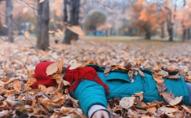 Kız sonbahar şehir parkında yaprak düşer. Genç güzel wi anne