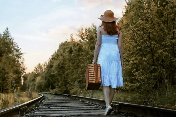 Autunno parco ragazza in sundress bianco e una valigia di vimini a piedi — Foto Stock