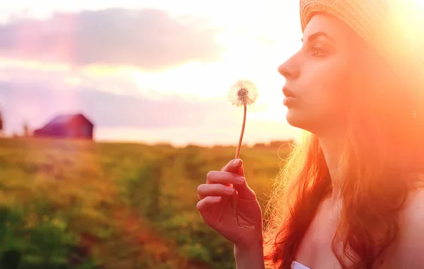 Ragazza in primavera sul campo. Una ragazza con una valigia cammina — Foto Stock