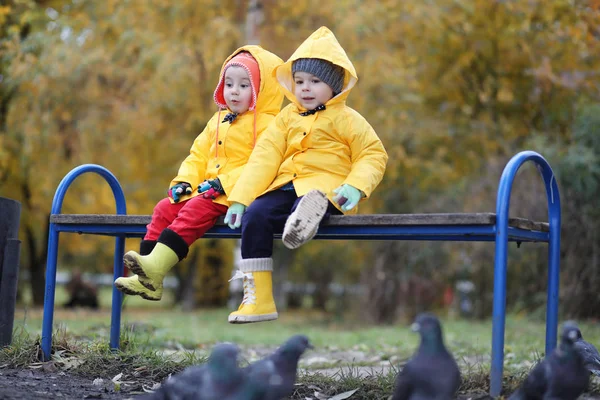 Ett barn i en regnrock för en promenad utanför — Stockfoto