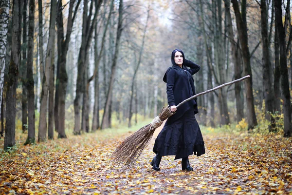 Une femme en costume de sorcière dans une forêt — Photo