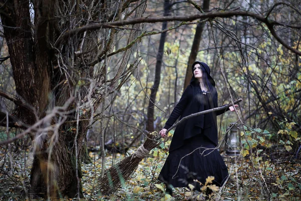 Una donna in abito da strega in una foresta — Foto Stock