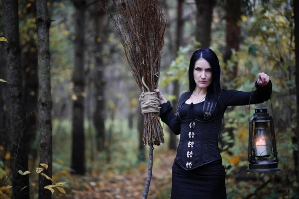 Une femme en costume de sorcière dans une forêt — Photo