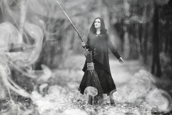 Žena v šatech čarodějnice v hustém lese — Stock fotografie