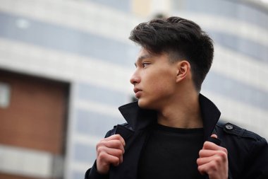 Asya genç adam sokakta bir ceket