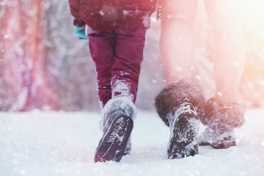 Çocuklu genç aile kış parkta yürüyüş. Winte