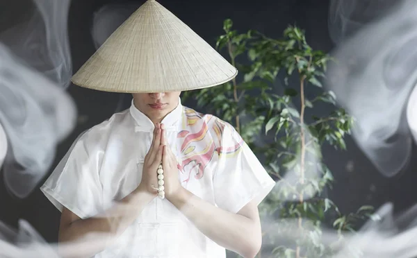 Азиат в кимоно молится с книгой — стоковое фото