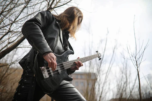 Guitariste rock sur les marches. Un musicien avec une guitare basse dans un — Photo