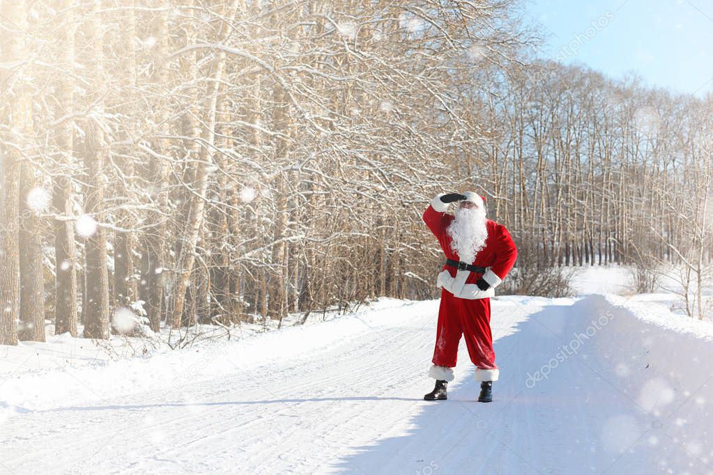 Santa Claus comes with gifts from the outdoor. Santa in a red su