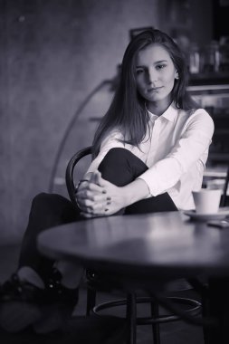 Bir kız bir kafede kahve içiyor. Bir kadın kahvaltı yapıyor