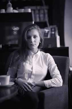 Bir kız bir kafede kahve içiyor. Bir kadın kahvaltı yapıyor