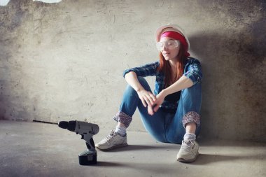 Kız dairede tamirat yapıyor. Eve yeni bir daireye taşınıyor. İşçi onarım, sıvalı yapar ve duvar matkaplar.