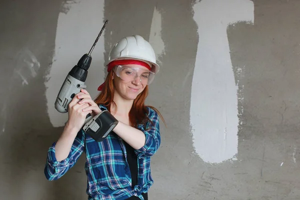 The girl is doing repairs in the apartment. Home moving to a new apartment. The worker makes repairs, plastered and drills the wall.