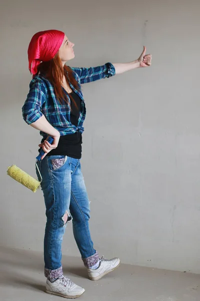 The girl is doing repairs in the apartment. Home moving to a new apartment. The worker makes repairs, plastered and drills the walls.