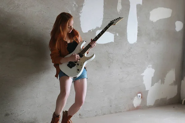 Menina ruiva jovem com uma guitarra elétrica. Músico de rock gir — Fotografia de Stock