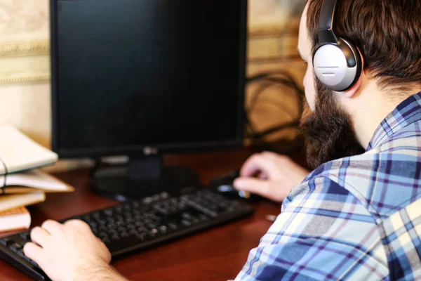 man play computer with headphones