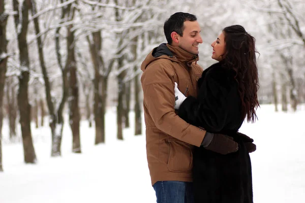 Un jeune couple se promène dans un parc d'hiver — Photo