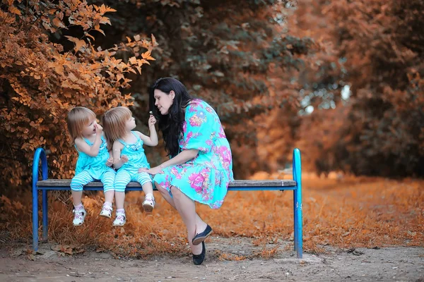 Mom with two daughters twins autumn