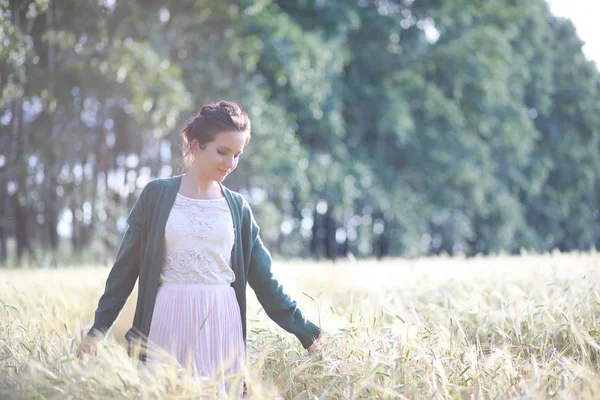 Uma jovem mãe caminha em campos de trigo — Fotografia de Stock