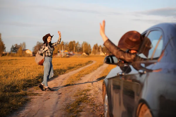 Una joven está viajando por la ciudad haciendo autostop. Una belleza. — Foto de Stock