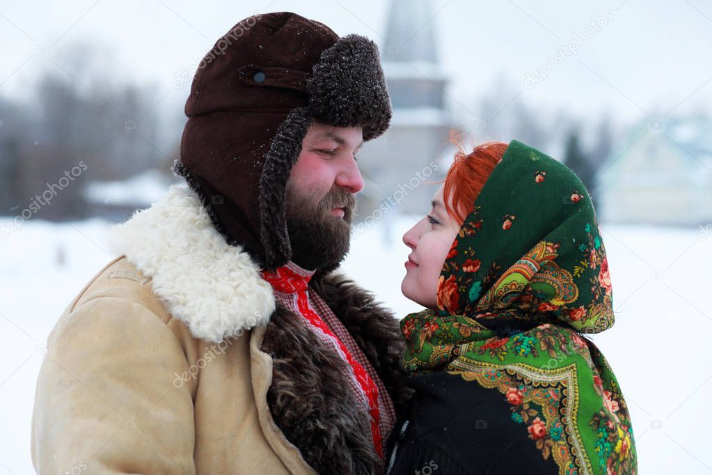 Couple in traditional winter costume of peasant in russia