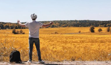 Genç bir adam doğal olarak dolaşıyor. Sırt çantasıyla seyahat eden