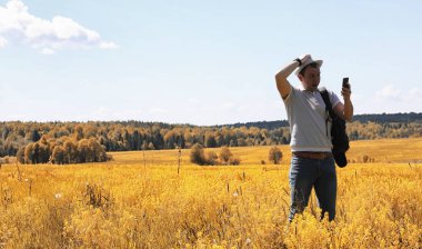 Genç bir adam doğal olarak dolaşıyor. Sırt çantasıyla seyahat eden