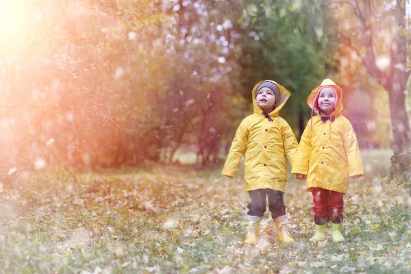 Ett barn i en regnrock en promenad utanför i höst — Stockfoto