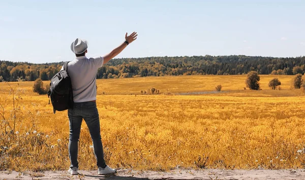 A young man is traveling in nature. Traveling with a backpack on — Stock Photo, Image