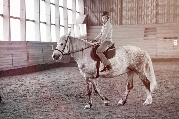 Jongeren op een paardentraining in houten arena — Stockfoto