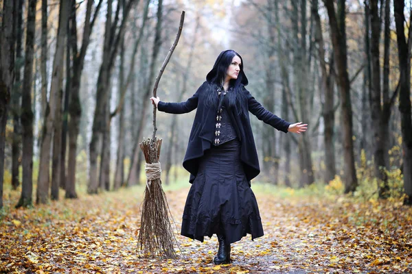 Una mujer con un traje de bruja en un bosque — Foto de Stock