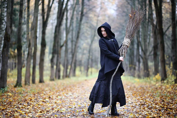 Una mujer con un traje de bruja en un bosque — Foto de Stock