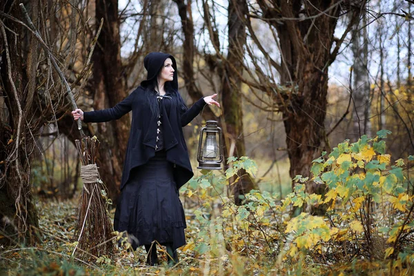 Une femme en costume de sorcière dans une forêt — Photo