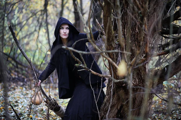 Une femme en costume de sorcière dans une forêt — Photo