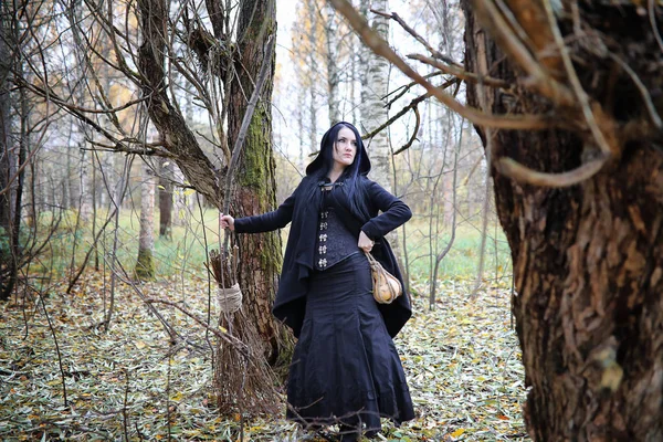 Una donna in abito da strega in una foresta — Foto Stock
