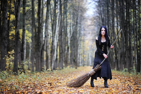 Une femme en costume de sorcière dans une forêt — Photo