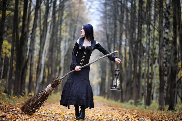 Una donna in abito da strega in una foresta — Foto Stock