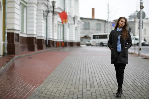 Молодая взрослая девушка в пальто на улице — стоковое фото