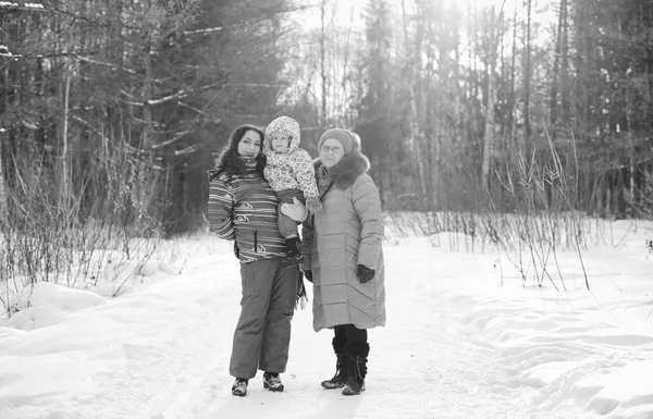 Foto en blanco y negro de los padres sosteniendo al niño en las manos en invierno p — Foto de Stock