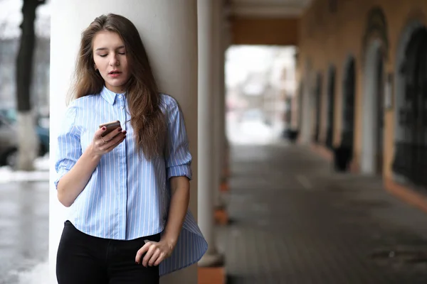 Joven hermosa chica en un paseo cerca del edificio con una columna —  Fotos de Stock