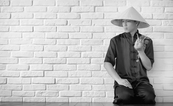 Азиатский новичок на белой кирпичной стене — стоковое фото