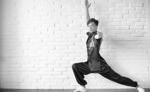 Asian novice on a white brick wall — Stock Photo, Image