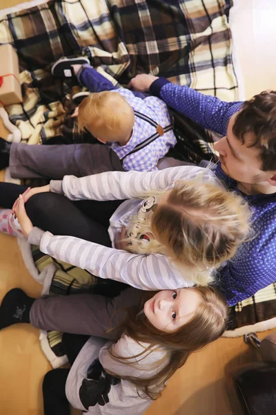 Familie verwarmd door de open haard zittend op de bank — Stockfoto